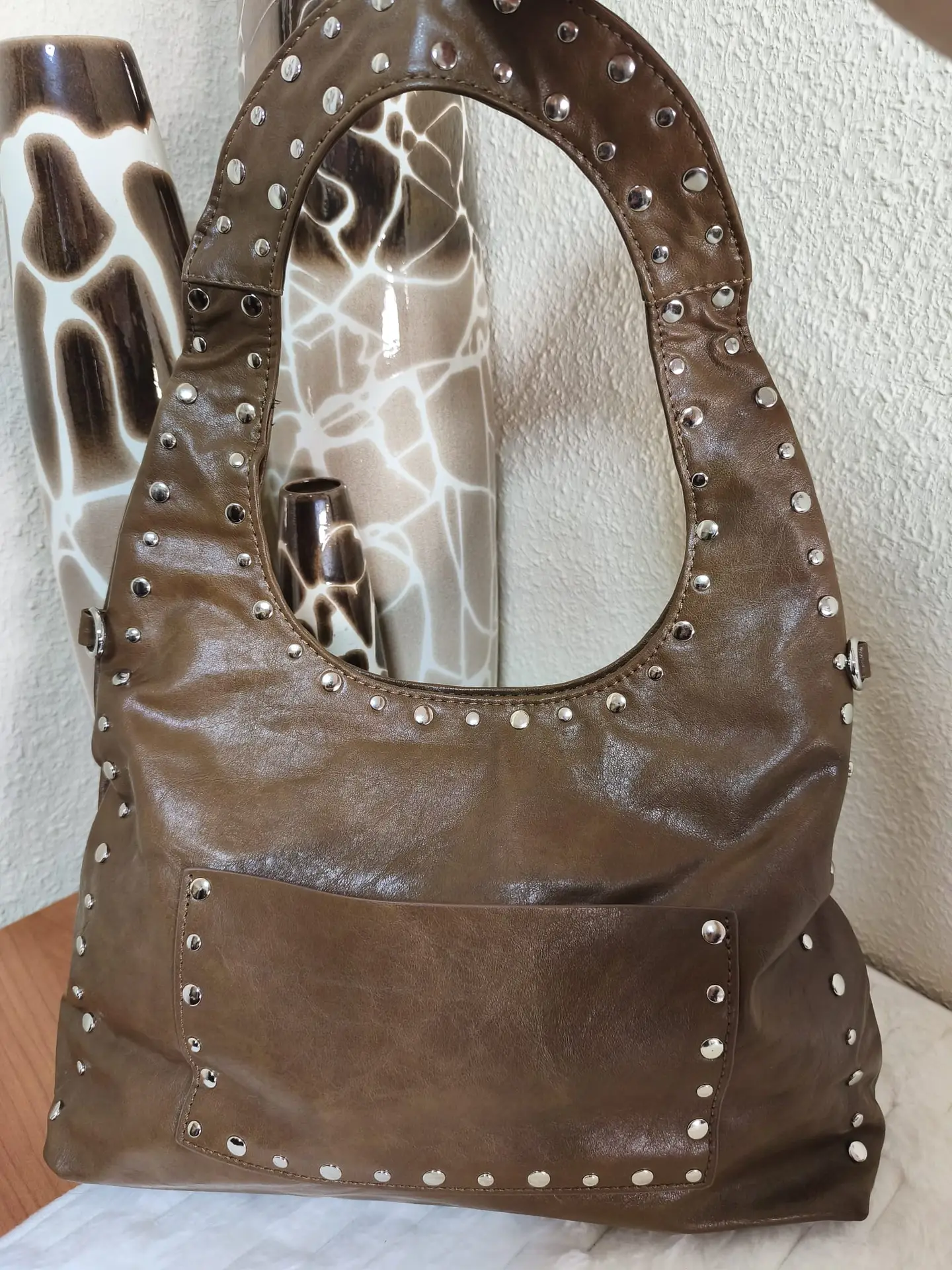 Bolso marrón con tachas y asa ancha